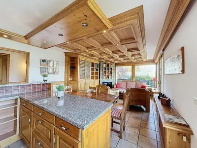 a kitchen with wooden ceilings and a dining room with a table at Chalet 9 personnes à Combloux, Mont Blanc - FR-1-560-125 in Combloux