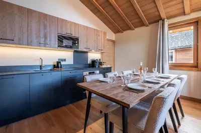 a kitchen with a wooden table and some chairs at Megève appartement 4 pièces résidence de standing in Megève