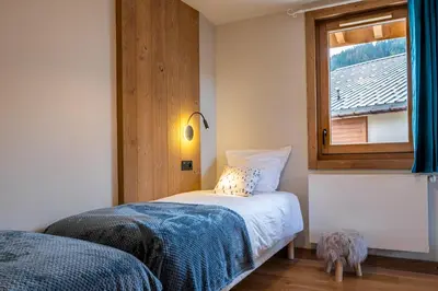 a small bedroom with a bed and a window at Megève appartement 4 pièces résidence de standing in Megève