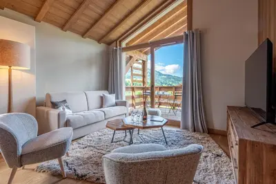a living room with a couch and a table and chairs at Megève appartement 4 pièces résidence de standing in Megève