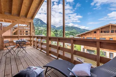 a balcony with chairs and a table and mountains at Megève appartement 4 pièces résidence de standing in Megève