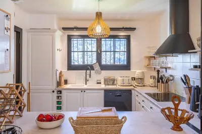 a kitchen with white cabinets and a sink and a window at Chalet Soleil Blanc au pied des pistes in Saint-Gervais-les-Bains