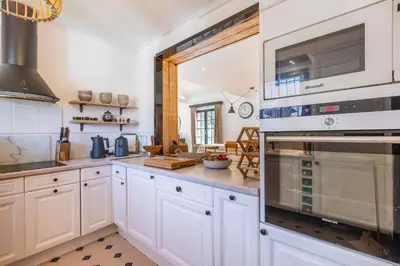 a kitchen with white cabinets and an oven at Chalet Soleil Blanc au pied des pistes in Saint-Gervais-les-Bains