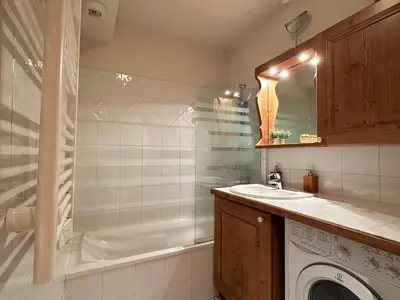 a bathroom with a shower and a sink and a washing machine at Confortable Appartement T3 au Centre avec Animaux admis - FR-1-624-158 in Samoëns