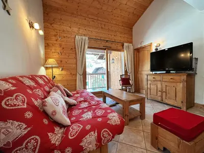 a living room with a bed and a flat screen tv at Confortable Appartement T3 au Centre avec Animaux admis - FR-1-624-158 in Samoëns