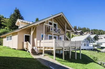 a house with a large deck on a hill at Les Chalets de Flaine Hameau - maeva Home - Chalet 7 Pièces 12 Personnes - Prestige MAE-3379 in Flaine