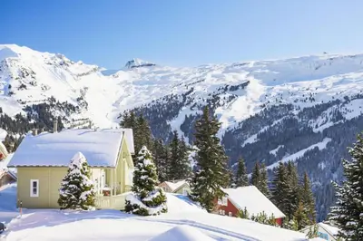 a house in the snow with mountains in the background at Les Chalets de Flaine Hameau - maeva Home - Chalet 7 Pièces 12 Personnes - Prestige MAE-3379 in Flaine
