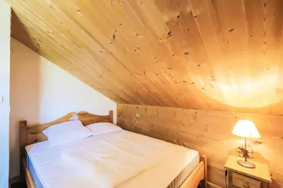 a bed in a room with a wooden ceiling at Les Chalets de Flaine Hameau - maeva Home - Chalet 7 Pièces 12 Personnes - Prestige MAE-3379 in Flaine