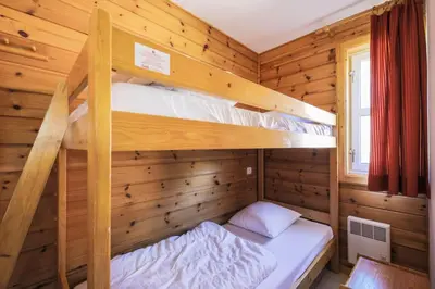 a bedroom with two bunk beds in a wooden cabin at Les Chalets de Flaine Hameau - maeva Home - Chalet 4 Pièces 8 Personnes - Sélection MAE-3386 in Flaine