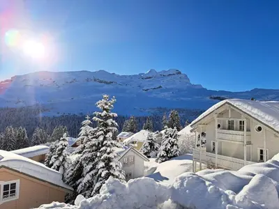 a house covered in snow with a mountain in the background at Les Chalets de Flaine Hameau - maeva Home - Chalet 3 Pièces 8 Personnes - Confort MAE-3392 in Flaine