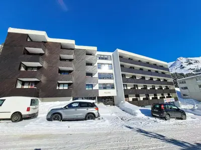 two cars parked in a parking lot in front of a building at Résidence Pégase - maeva Home - Appartement 3 pièces 8 personnes Confort MAE-3481 in Flaine