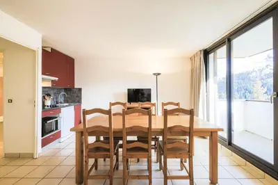 a kitchen and dining room with a wooden table and chairs at Résidence Pégase - maeva Home - Appartement 3 pièces 8 personnes Confort MAE-3481 in Flaine