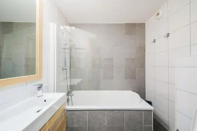 a white bathroom with a tub and a sink at Résidence Refuge du Golf - maeva Home - Appartement 2 pièces 4 personnes Prestige MAE-3482 in Arâches-la-Frasse