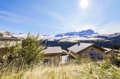 a group of houses with snow covered mountains in the background at Résidence Refuge du Golf - maeva Home - Appartement 2 pièces 4 personnes Prestige MAE-3482 in Arâches-la-Frasse