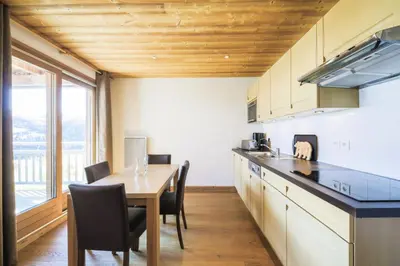 a kitchen with a table and chairs and a dining room at Résidence Refuge du Golf - maeva Home - Appartement 2 pièces 4 personnes Prestige MAE-3482 in Arâches-la-Frasse