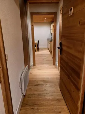 a hallway leading to a kitchen with a wooden floor at Résidence Refuge du Golf - maeva Home - Appartement 2 pièces 4 personnes Prestige MAE-3482 in Arâches-la-Frasse