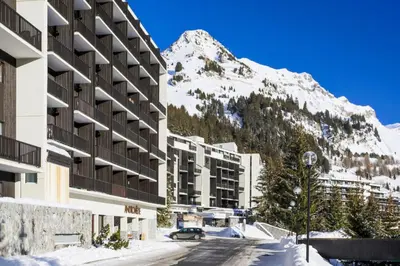 a snow covered mountain in front of a building at Résidence Andromède - maeva Home - Studio 4 personnes Confort MAE-3516 in Flaine