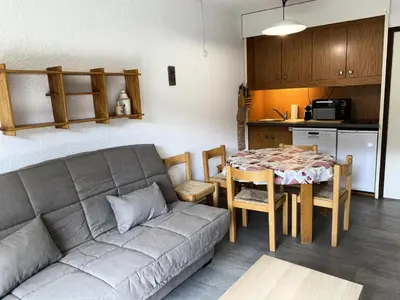 a living room with a couch and a table and a kitchen at Résidence Andromède - maeva Home - Studio 4 personnes Confort MAE-3516 in Flaine