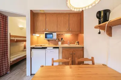 a small kitchen with a table and a bunk bed at Résidence Andromède - maeva Home - Studio 4 Personnes - Confort MAE-3651 in Flaine
