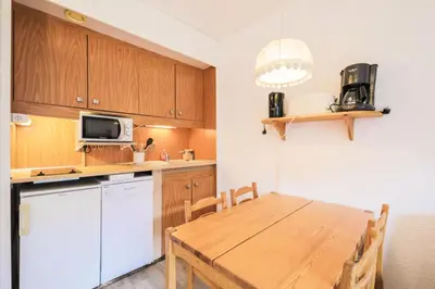 a kitchen with a wooden table and a microwave at Résidence Andromède - maeva Home - Studio 4 Personnes - Confort MAE-3651 in Flaine