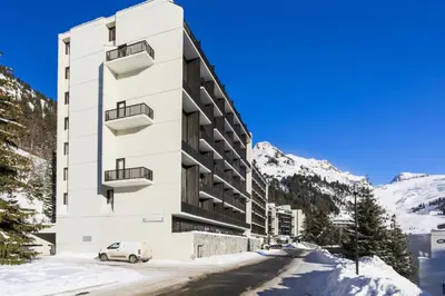 a white building with a car parked in front of it at Résidence Andromède - maeva Home - Studio 4 Personnes - Confort MAE-3653 in Flaine