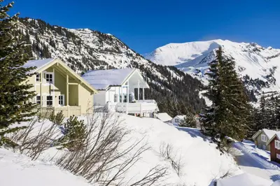 a house in the snow with mountains in the background at Les Chalets de Flaine Hameau - maeva Home - Chalet 3 Pièces 8 Personnes - Confort MAE-3654 in Flaine