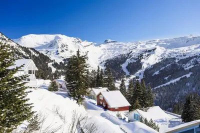 a snow covered mountain with a house in the foreground at Les Chalets de Flaine Hameau - maeva Home - Chalet 3 Pièces 8 Personnes - Confort MAE-3654 in Flaine