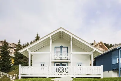 a white house with a porch and a balcony at Les Chalets de Flaine Hameau - maeva Home - Chalet 5 Pièces 8 Personnes - Prestige MAE-3655 in Flaine