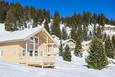 a home in the snow with trees in the background at Les Chalets de Flaine Hameau - maeva Home - Chalet 5 Pièces 8 Personnes - Prestige MAE-3655 in Flaine