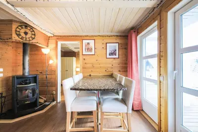a dining room with a table and chairs and a stove at Les Chalets de Flaine Hameau - maeva Home - Chalet 5 Pièces 8 Personnes - Prestige MAE-3655 in Flaine