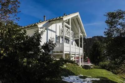 a white house with a porch on a hill at Les Chalets de Flaine Hameau - maeva Home - Chalet 7 Pièces 12 Personnes - Sélection MAE-3656 in Flaine