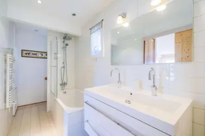 a white bathroom with a sink and a tub and a sinkonnaissance at Les Chalets de Flaine Hameau - maeva Home - Chalet 7 Pièces 12 Personnes - Sélection MAE-3656 in Flaine
