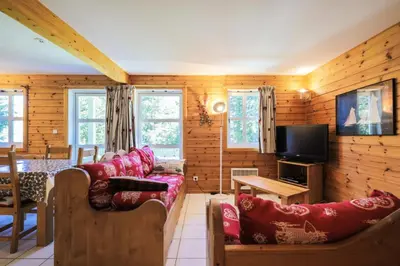a living room with wooden walls and red furniture at Les Chalets de Flaine Hameau - maeva Home - Chalet 4 Pièces 8 Personnes - Confort MAE-3660 in Flaine