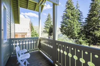 a porch with two chairs and a view of trees at Les Chalets de Flaine Hameau - maeva Home - Chalet 4 Pièces 8 Personnes - Confort MAE-3660 in Flaine