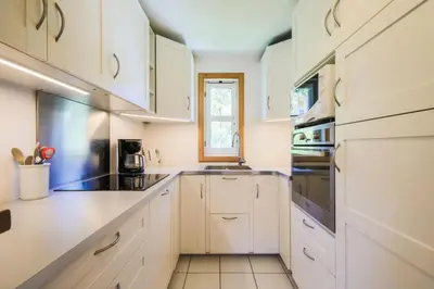 a white kitchen with white cabinets and a window at Les Chalets de Flaine Hameau - maeva Home - Chalet 4 Pièces 8 Personnes - Confort MAE-3660 in Flaine