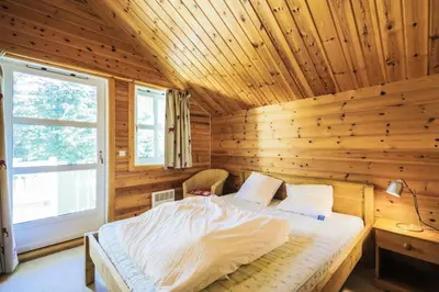 a bedroom with a bed in a wooden cabin at Les Chalets de Flaine Hameau - maeva Home - Chalet 4 Pièces 8 Personnes - Confort MAE-3660 in Flaine