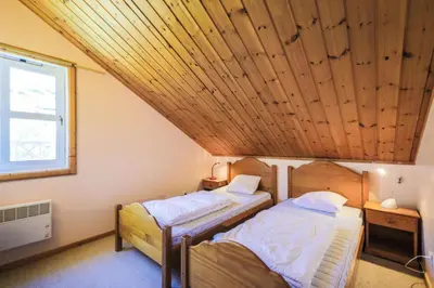 two beds in a room with a wooden ceiling at Les Chalets de Flaine Hameau - maeva Home - Chalet 4 Pièces 8 Personnes - Confort MAE-3660 in Flaine
