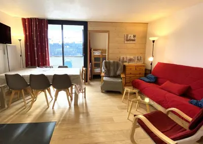 a living room with a red couch and a table at Résidence Pégase - maeva Home - Appartement 3 Pièces 8 personnes - Sélection MAE-3663 in Flaine
