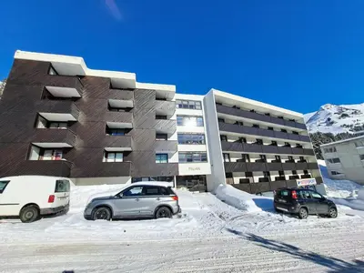 two cars parked in a parking lot in front of a building at Résidence Pégase - maeva Home - Appartement 3 Pièces 8 personnes - Sélection MAE-3663 in Flaine