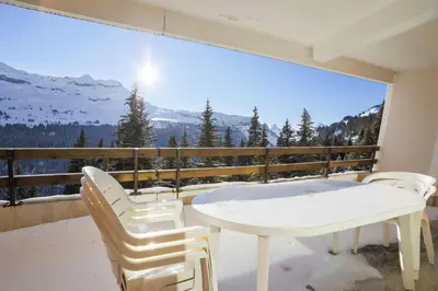 a balcony with a white table and chairs and a large window at Résidence Arche - maeva Home - Appartement 2 Pièces 6 Personnes - Confort MAE-3694 in Arâches-la-Frasse