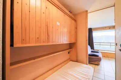 a bedroom with wooden walls and a bed and a window at Résidence Arche - maeva Home - Studio 4 Personnes - Confort MAE-3695 in Arâches-la-Frasse