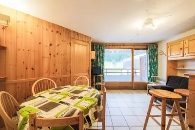a room with a bed and a table and chairs at Résidence Arche - maeva Home - Appartement 2 Pièces 6 Personnes - Confort MAE-3696 in Arâches-la-Frasse