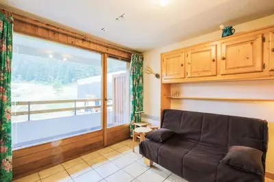 a living room with a couch and a large window at Résidence Arche - maeva Home - Appartement 2 Pièces 6 Personnes - Confort MAE-3696 in Arâches-la-Frasse