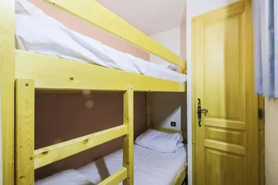 two bunk beds in a small room with a door at Résidence Arche - maeva Home - Appartement 2 Pièces 6 Personnes - Confort MAE-3696 in Arâches-la-Frasse