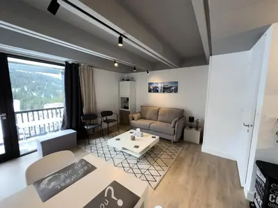 a living room with a couch and a table at Résidence Aldébaran - maeva Home - Appartement 2 Pièces 6 Personnes - Prestige MAE-3791 in Arâches-la-Frasse
