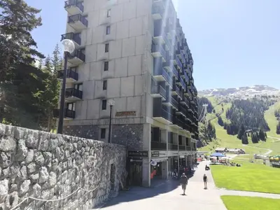 a building on a hill with people walking in front of it at Résidence Aldébaran - maeva Home - Appartement 2 Pièces 6 Personnes - Prestige MAE-3791 in Arâches-la-Frasse