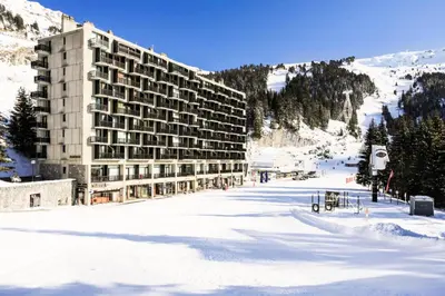 a large building in the snow in front of a mountain at Résidence Aldébaran - maeva Home - Appartement 2 Pièces 6 Personnes - Budget MAE-3792 in Arâches-la-Frasse