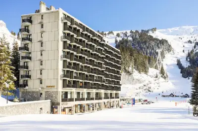 a building in the snow in front of a mountain at Résidence Aldébaran - maeva Home - Studio 4 personnes - Confort MAE-3799 in Arâches-la-Frasse