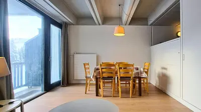 a dining room with a table and yellow chairs at Résidence Aldébaran - maeva Home - Appartement 2 Pièces 6 Personnes - Confort MAE-3806 in Arâches-la-Frasse