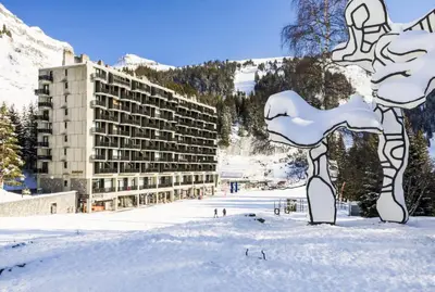 a building in the snow in front of a mountain at Résidence Aldébaran - maeva Home - Appartement 2 Pièces 6 Personnes - Confort MAE-3806 in Arâches-la-Frasse